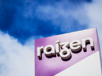 Logotipo da Raízen em destaque na fachada de um prédio com céu azul ao fundo.