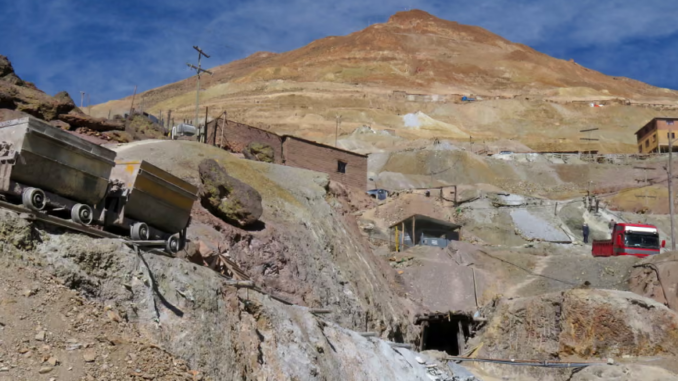 Mina de prata em Potosí, Bolívia, com vagões de mineração e terreno montanhoso.