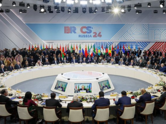 Líderes reunidos em cúpula do BRICS com representantes de vários países em mesa redonda.