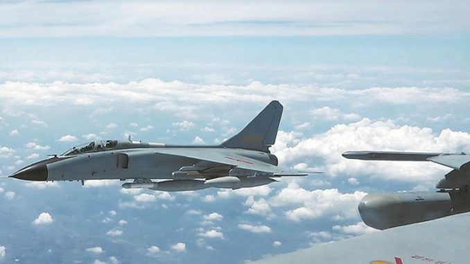 Aeronave militar chinesa sobrevoa o Estreito de Taiwan durante exercícios de fogo real, com céu parcialmente nublado ao fundo.