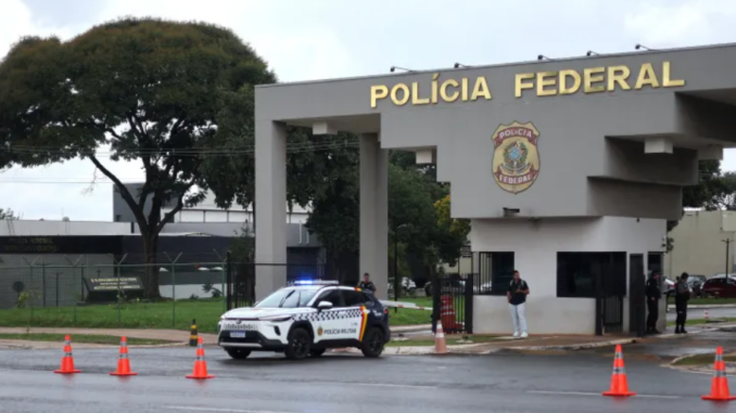 Entrada da sede da Polícia Federal com viatura e agentes durante operação relacionada a investigados por tentativa de golpe.