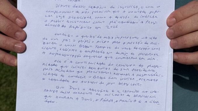Flávio Bolsonaro segurando a carta manuscrita de Jair Bolsonaro, intitulada "Carta aos Brasileiros", com texto escrito à mão e assinatura ao final.
