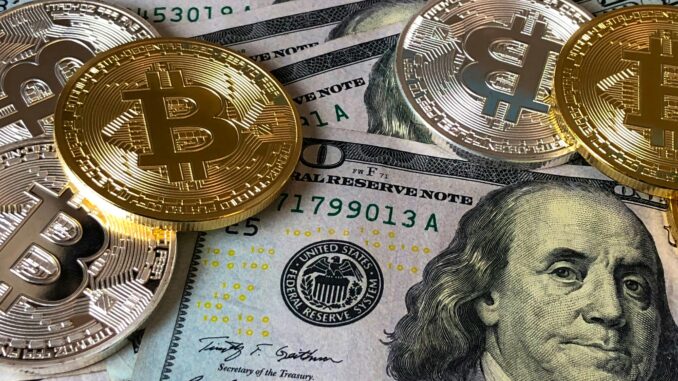 Moedas de Bitcoin sobre notas de dólar americano.