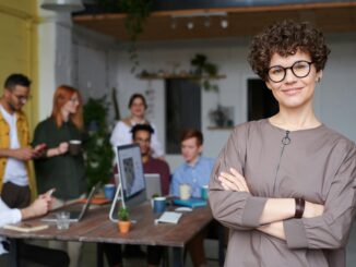 Empreendedora em ambiente de trabalho colaborativo com equipe ao fundo