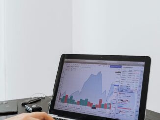 Investidor analisa gráfico de mercado financeiro em laptop, com variação de preços e volumes, em contexto de análise técnica do Ibovespa e contratos futuros