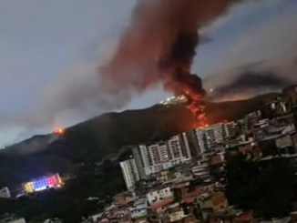 Explosão registrada em Fuerte Tiuna, a maior base militar da Venezuela, com coluna de fumaça e fogo visível sobre Caracas durante ofensiva militar.
