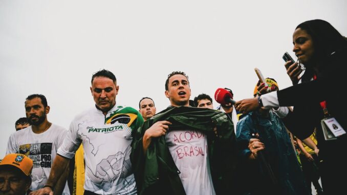 Nikolas Ferreira durante a Caminhada pela Liberdade, em mobilização rumo a Brasília, cercado por apoiadores e imprensa.